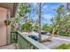 Balcony with green railings offering views of the lush greenery and carports below at 1532 Pelican Point Dr # 240, Sarasota, FL 34231