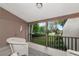 Enclosed balcony with wicker seating offers views of the lush landscaping and pool at 1532 Pelican Point Dr # 240, Sarasota, FL 34231