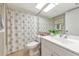 Bathroom with a shower-tub combo with patterned shower curtain, bright vanity and large mirror at 1532 Pelican Point Dr # 240, Sarasota, FL 34231