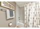 Full bathroom featuring a tub with shower, framed art, and soft, neutral color tones at 1532 Pelican Point Dr # 240, Sarasota, FL 34231