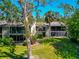Rear condo exterior with mature landscaping and multiple balconies, nestled amongst native Florida vegetation at 1532 Pelican Point Dr # 240, Sarasota, FL 34231