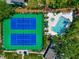 Overhead view of pristine blue tennis courts adjacent to a sparkling community pool and sunbathing area at 1532 Pelican Point Dr # 240, Sarasota, FL 34231