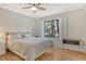 Comfortable bedroom featuring a ceiling fan, window views, and hardwood floors at 1532 Pelican Point Dr # Ba139, Sarasota, FL 34231