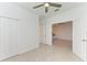 Bedroom featuring tiled floors, ceiling fan, closet, and double doors at 15503 Sunny Day Dr, Bradenton, FL 34211