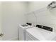 Laundry room featuring washer, dryer, wire shelving, and tiled floors at 15503 Sunny Day Dr, Bradenton, FL 34211