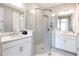 This bathroom features dual vanities, a walk-in glass shower, and white cabinetry at 16134 Paynes Mill Dr, Bradenton, FL 34211