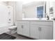 Bright bathroom featuring a tiled shower and tub, sleek white vanity, modern fixtures and a large mirror at 16134 Paynes Mill Dr, Bradenton, FL 34211
