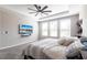 This bedroom features neutral colors, a ceiling fan, large windows, and a wall-mounted television at 16134 Paynes Mill Dr, Bradenton, FL 34211