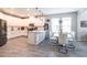 Modern kitchen features stainless appliances, white cabinetry, an island, and a dining space with modern chairs at 16134 Paynes Mill Dr, Bradenton, FL 34211