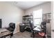 Home office featuring two desks with black leather chairs, storage shelves and natural light from the window at 16134 Paynes Mill Dr, Bradenton, FL 34211