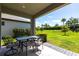 Covered patio offering a peaceful outdoor space, complete with a seating area and a lush green lawn at 16134 Paynes Mill Dr, Bradenton, FL 34211