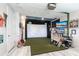 Finished room has a golf simulator, two TVs, decorations, and a faux brick accent wall at 16134 Paynes Mill Dr, Bradenton, FL 34211