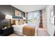 Stylish bedroom featuring a large window, neutral tones, and decorative lamps on a black bedside table at 16622 San Nicola Pl, Bradenton, FL 34211