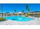 Sparkling blue pool surrounded by palm trees, lounge chairs, and cabanas, ideal for summer fun at 16622 San Nicola Pl, Bradenton, FL 34211