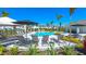 A luxurious pool area featuring cabanas, lounge chairs, and lush landscaping under a sunny sky at 16622 San Nicola Pl, Bradenton, FL 34211