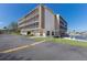 Low angle view of a waterfront condo with parking, green space, and boat dock on a sunny day at 1714 69Th W Ave # C402, Bradenton, FL 34207