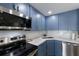 Close up of kitchen with blue cabinets, white countertops and backsplash, and stainless steel appliances at 1714 69Th W Ave # C402, Bradenton, FL 34207