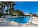 Large community pool with lounge chairs and palm trees on a sunny day at 1714 69Th W Ave # C402, Bradenton, FL 34207