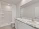 Clean, modern bathroom with dual sinks, granite countertop, and walk-in shower at 17620 Crescent Moon Loop, Bradenton, FL 34211
