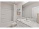 Well-lit bathroom featuring a tub with shower, white vanity with marble top, and modern finishes at 17620 Crescent Moon Loop, Bradenton, FL 34211