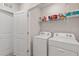 Clean laundry room with new washer and dryer and organized shelving at 17620 Crescent Moon Loop, Bradenton, FL 34211