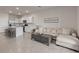 Open-concept living room featuring a modern kitchen, tile flooring, and comfortable seating at 17620 Crescent Moon Loop, Bradenton, FL 34211