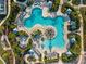 Aerial shot of a large community pool surrounded by lounge chairs, cabanas, and tropical plants at 17620 Crescent Moon Loop, Bradenton, FL 34211
