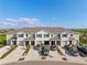 Three-story townhomes with garages and driveway parking are set against a clear blue sky at 17620 Crescent Moon Loop, Bradenton, FL 34211