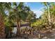 Steps lead down to the waterfront dock. Lush trees add to the view at 2105 Georgia Ave, Englewood, FL 34224