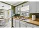 Bright kitchen featuring white cabinets, a double stainless steel sink, and a window view at 2105 Georgia Ave, Englewood, FL 34224