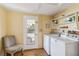 Functional laundry room with washer, dryer, storage shelves, and access to the outdoors at 2105 Georgia Ave, Englewood, FL 34224