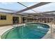 A refreshing in-ground pool sits within a screened enclosure, perfect for relaxing and entertaining outdoors at 2105 Georgia Ave, Englewood, FL 34224