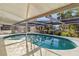 Inviting in-ground pool enclosed by a screen, offering a private oasis for leisure and enjoyment at 2105 Georgia Ave, Englewood, FL 34224