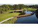 Scenic golf course view with a charming bridge over a serene lake at 223 Saint James Park, Osprey, FL 34229