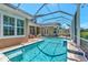 Beautiful pool with a screened-in lanai, tanning ledge, and lush landscaping creating a private outdoor oasis at 223 Saint James Park, Osprey, FL 34229