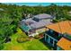 Aerial view of home with screened-in pool overlooking lush lawn and landscaped gardens at 223 Saint James Park, Osprey, FL 34229