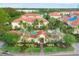 Aerial view of community with red tile roofs, lush landscaping, and a sparkling pool area at 232 Explorer Dr # 15, Osprey, FL 34229