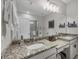 Bathroom featuring a granite countertop, dual sinks, and a spacious shower with a glass door at 232 Explorer Dr # 15, Osprey, FL 34229