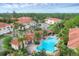 Aerial view of a luxurious community pool surrounded by lush landscaping and residential buildings with tile roofs at 232 Explorer Dr # 15, Osprey, FL 34229