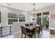 Elegant dining room with a modern chandelier, large window, and easy access to the outdoor patio at 232 Explorer Dr # 15, Osprey, FL 34229