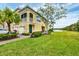 Charming yellow townhome featuring lush landscaping, a screened-in porch, and a beautiful waterfront view at 232 Explorer Dr # 15, Osprey, FL 34229