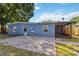 A home with a blue exterior with a paver patio and screened in patio in the backyard at 2400 Stanford Ave, Bradenton, FL 34207