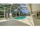 Screened-in pool with a view of trees, with chairs for outdoor entertaining at 241 Willow Bend Way, Osprey, FL 34229