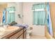 A dated bathroom featuring a salmon sink and tile with a blue shower curtain at 2417 6Th Avenue E Dr, Bradenton, FL 34208
