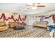 Bright living room with patterned carpet, ceiling fans, and traditional furnishings at 2417 6Th Avenue E Dr, Bradenton, FL 34208