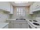 Bright kitchen features white cabinets, countertops, and appliances, and a window with lots of natural light at 2819 Swifton Dr # 9, Sarasota, FL 34231