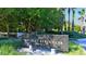 A sign for Bay Isles Beach Club, a private community with lush landscaping at 3080 Grand Bay Blvd # 533, Longboat Key, FL 34228