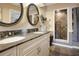 Bathroom featuring a dual sink vanity with granite countertops and tiled walk-in shower at 316 29Th W St, Bradenton, FL 34205