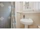 Neutral bathroom with white sink, storage, and gray tile shower accented with geometric tile and decorative curtain at 316 29Th W St, Bradenton, FL 34205