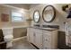 Bright bathroom featuring a dual sink vanity with granite countertops and decorative framed mirrors at 316 29Th W St, Bradenton, FL 34205